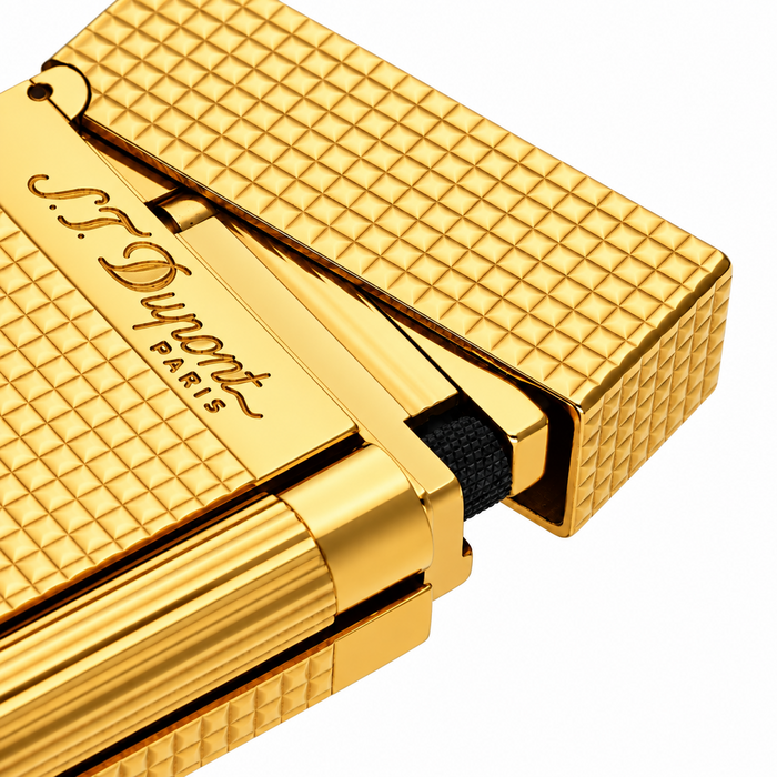 A close-up of an S. T. Dupont Ligne 2 pocket cigar lighter in a yellow gold-plated finish diamond-head guilloche pattern. Model 016284. A luxury soft-flame lighter for cigar smoking.