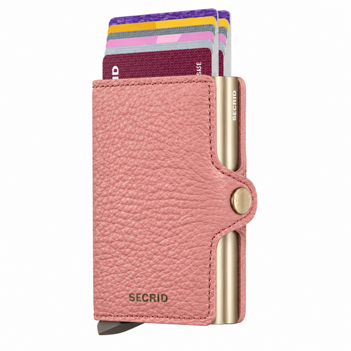 A pink textured leather Secrid wallet with gold-tone metal accents, shown with several cards partially inserted. The wallet has the brand name 'SECRID' embossed on the front and on the metal edge.