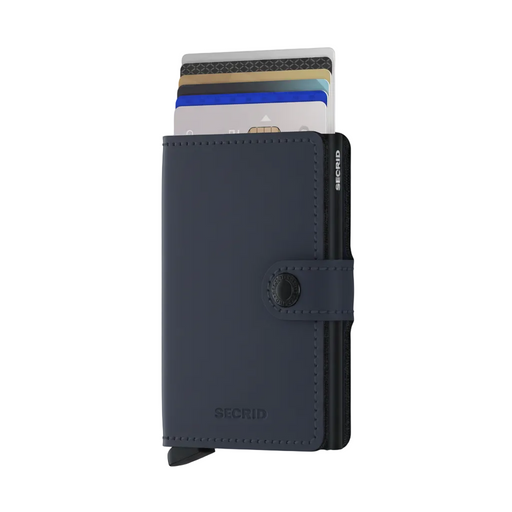 A navy blue Secrid minimalist cardholder wallet with a snap-button closure, shown standing upright with several credit cards partially inserted. The brand name 'SECRID' is embossed on the lower front and vertically on the side.