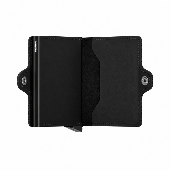 A black leather card holder Secrid wallet shown open, featuring the slim metal card protector on the left with the brand name 'SECRID' printed vertically in white, a card slot on the left side, and snap-button closures.