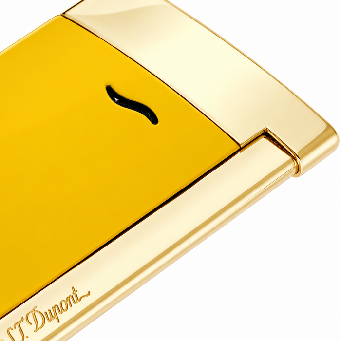 A close-up of an ultra thin S. T. Dupont Slim 7 pocket-torch lighter, featuring a smooth and vibrant honey-yellow lacquer body and polished gold-toned accents and striker. A premium torch-flame lighter, perfect for cigar smoking. Model 027775