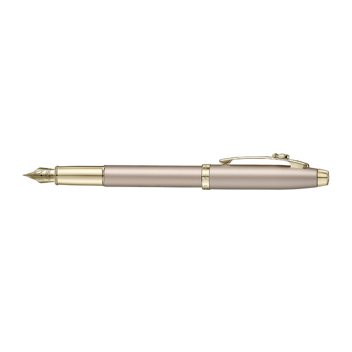A sleek Sheaffer 100  Emily in Paris fountain pen in a metallic champagne gold lacquer finish with champagne gold  trims and adorned with a bow-shaped emblem on the clip . Model E0937753